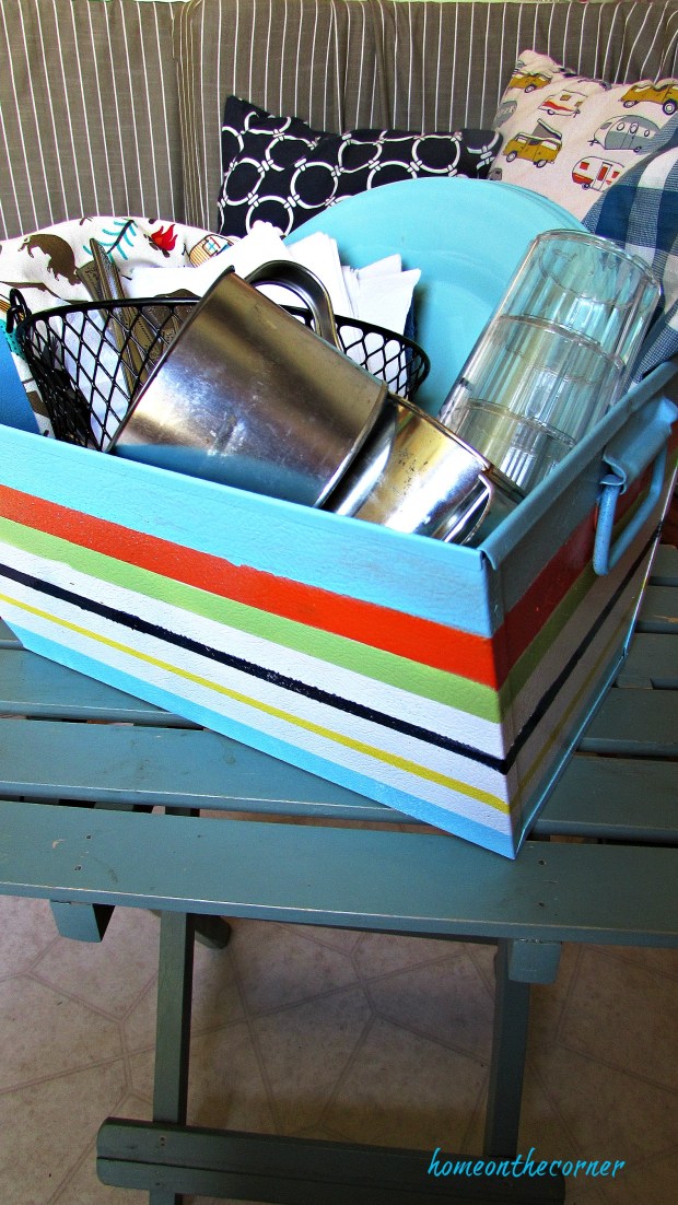 metal box with painted stripes and dishes